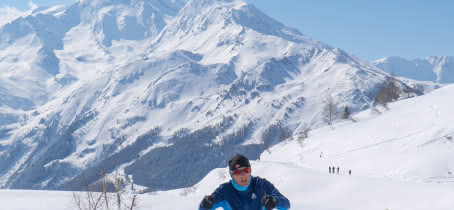 Skieur de fond avec cue dégagée sur les montagnes enneigées.